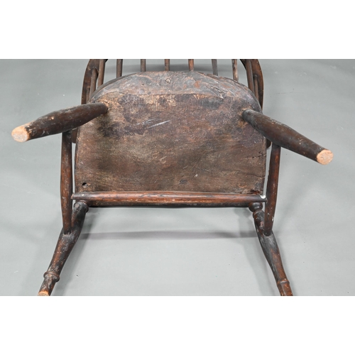 902 - An antique elm seat comb-back chair, raised on turned legs united by an H-stretcher