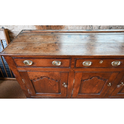 929 - An 18th century oak and elm low dresser base with three drawers over three fielded panel doors, with... 