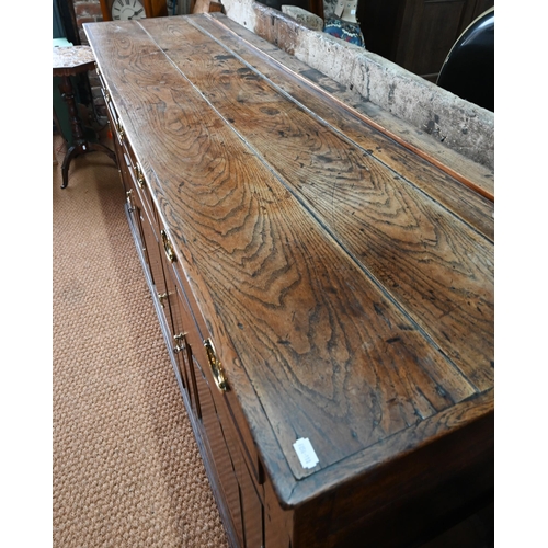 929 - An 18th century oak and elm low dresser base with three drawers over three fielded panel doors, with... 