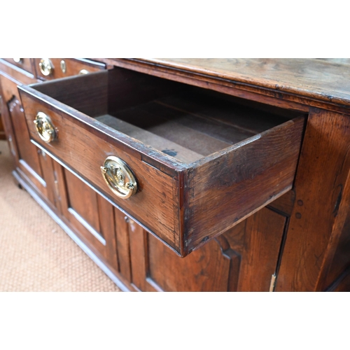 929 - An 18th century oak and elm low dresser base with three drawers over three fielded panel doors, with... 