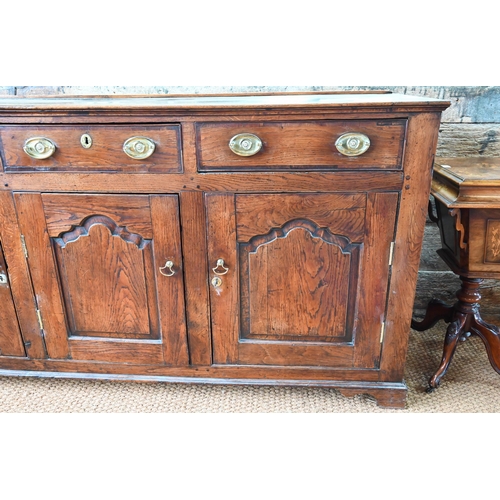 929 - An 18th century oak and elm low dresser base with three drawers over three fielded panel doors, with... 