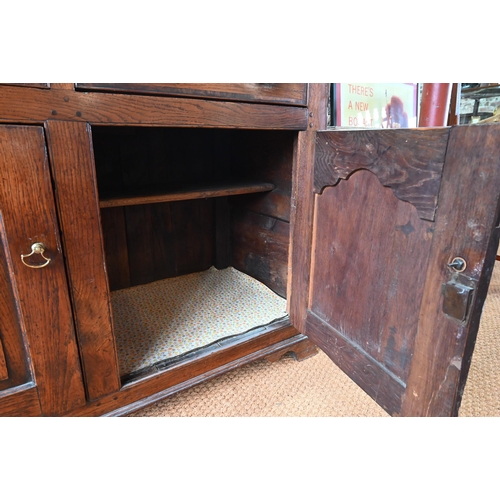 929 - An 18th century oak and elm low dresser base with three drawers over three fielded panel doors, with... 