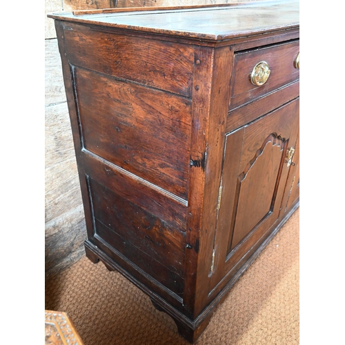 929 - An 18th century oak and elm low dresser base with three drawers over three fielded panel doors, with... 