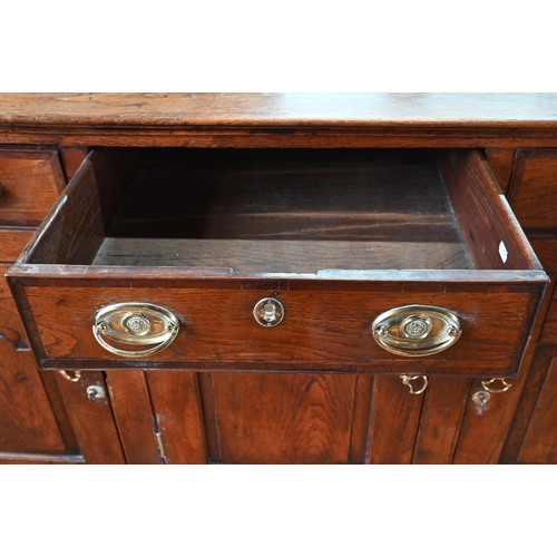 929 - An 18th century oak and elm low dresser base with three drawers over three fielded panel doors, with... 