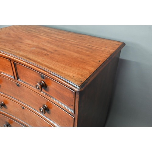 944 - A Georgian mahogany concave chest of two short over three long graduated drawers, with turned handle... 