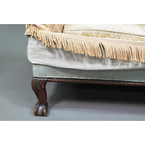 963 - A traditional two-seat sofa with gold silk loose covers over patterned undercloth, raised on hip car... 