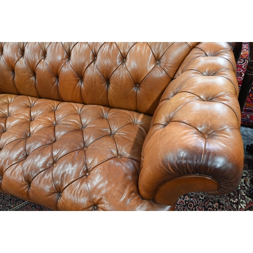 967 - A large contemporary antiqued buttoned brown leather Chesterfield style sofa and matching armchair, ... 