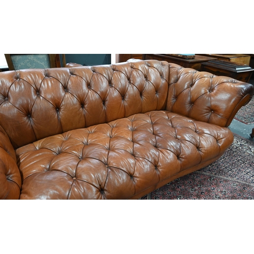 967 - A large contemporary antiqued buttoned brown leather Chesterfield style sofa and matching armchair, ... 