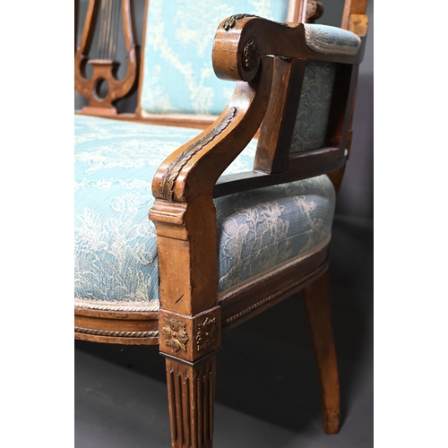 973 - An Edwardian walnut framed salon sofa, the back centred by a lyre splat flanked by fabric backrests,... 