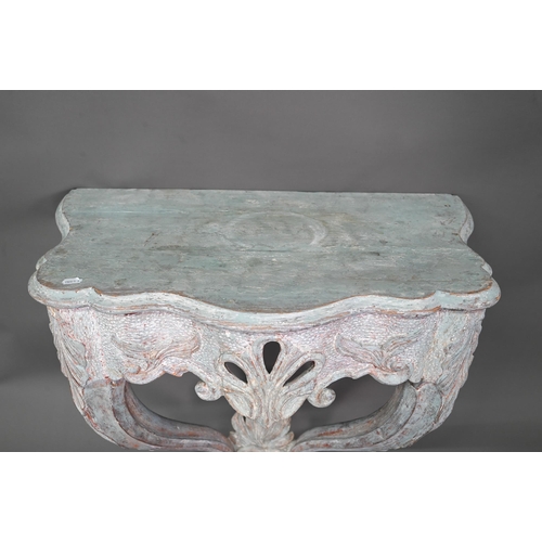 981 - An antique distress painted serpentine form console table, carved pine, raised on twin scroll legs u... 