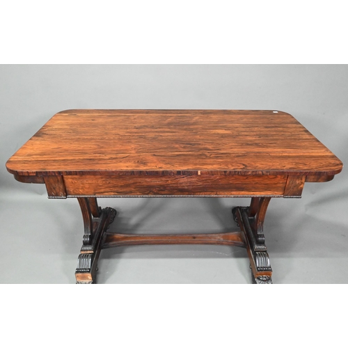 982 - A William IV rosewood library table, with single long frieze drawer, raised on twin scroll end suppo... 