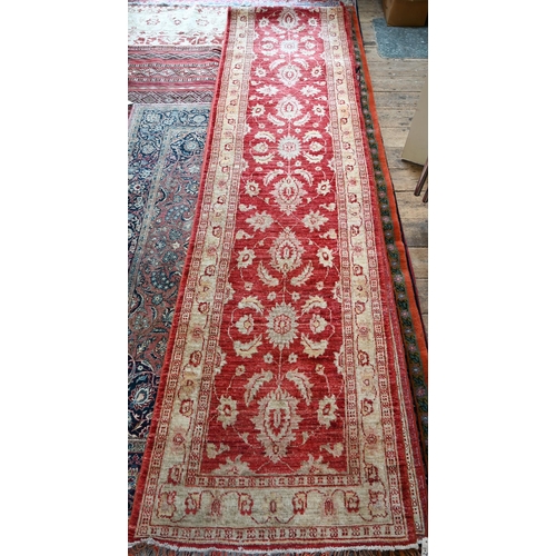 1072 - A contemporary Agra runner, soft red stylized floral design on pink and camel ground, 635 x 80 cm&nb... 