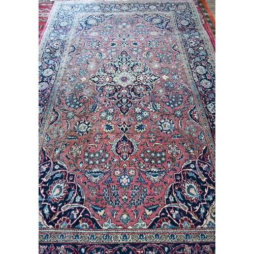 1073 - An antique Persian Kashan rug, the central medallion and floral vines on dull maroon ground, 204 x 1... 