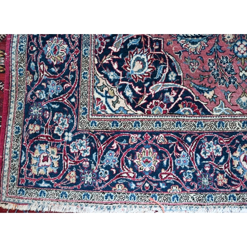 1073 - An antique Persian Kashan rug, the central medallion and floral vines on dull maroon ground, 204 x 1... 