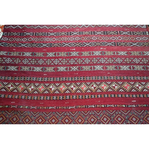 1074 - An old Persian Sumak flat weave carpet, the earth red ground  with multiple geometric design stripes... 