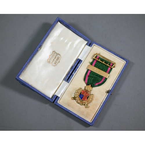 1161 - A 9ct gold and enamelled Rifle Association medal, the ribbon with 1934 bar and buckle pin, in fitted... 