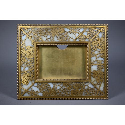 1209 - Tiffany Studios, New York, a gilt brass and mottled opaque glass panelled strut frame in the pine ne... 