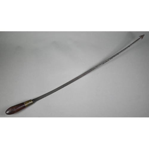 1283 - An antique weapon, the 60 cm curved steel blade with barbed finial, on brass-mounted rosewood hilt, ... 