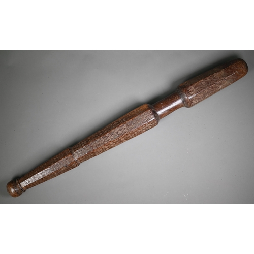 1305 - An antique hardwood tribal baton, multi-faceted and scratch carved with geometric and circular desig... 