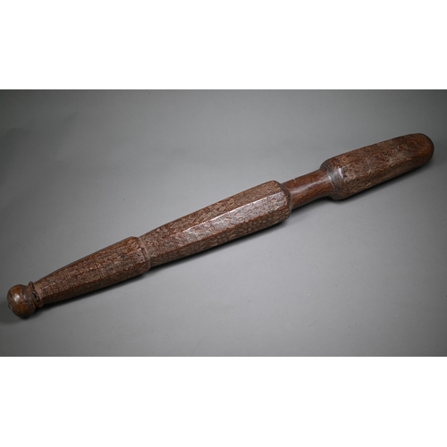 1305 - An antique hardwood tribal baton, multi-faceted and scratch carved with geometric and circular desig... 