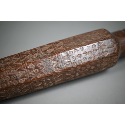 1305 - An antique hardwood tribal baton, multi-faceted and scratch carved with geometric and circular desig... 