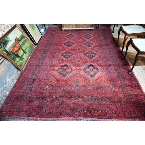 1069 - A contemporary Afghan carpet with two rows of stylised guls on red ground, 189 x 199 cm