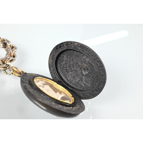 427 - A Victorian Whitby jet oval locket with cameo carved in high relief to front, and opening to reveal ... 
