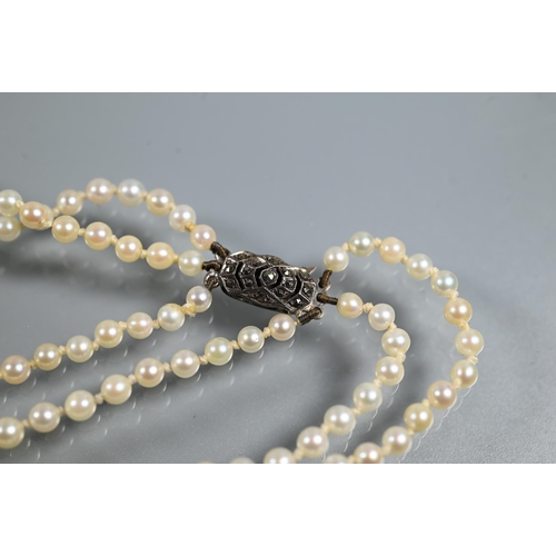 492 - A triple graduated row of cultured pearls by Lotus, double knotted throughout onto white metal snap,... 