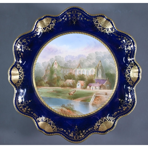 693 - A Victorian Minton china wall-plate painted with 'A View in The Vale of Llangollen' (title on revers... 