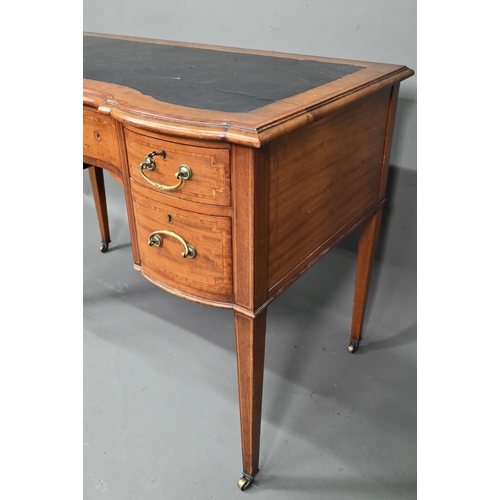 994 - A late 19th century cross-banded satinwood desk, the top with leather surface over five drawers, rai... 