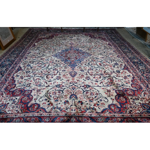 1066 - A fine Persian handmade Kashan carpet, the floral vine design on cream ground centred by a blue grou... 