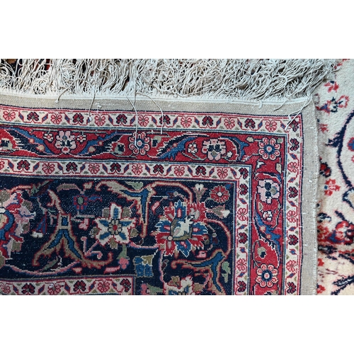 1066 - A fine Persian handmade Kashan carpet, the floral vine design on cream ground centred by a blue grou... 