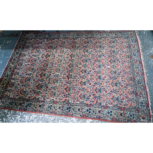 1068 - An antique Persian Qom rug, repeating floral vase design on camel ground, 220 cm x 138 cm