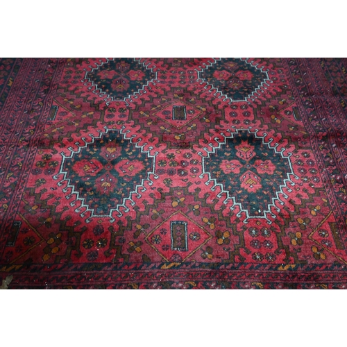 1069 - A contemporary Afghan carpet with two rows of stylised guls on red ground, 189 x 199 cm