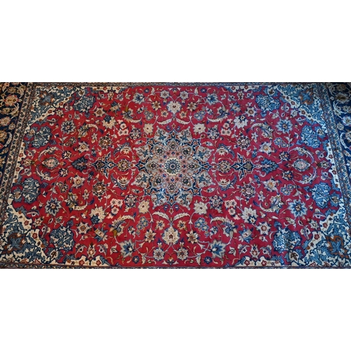 1079 - A central Persian Isfahan carpet, centred by a floral medallion on red ground, 380 cm x 285 cm