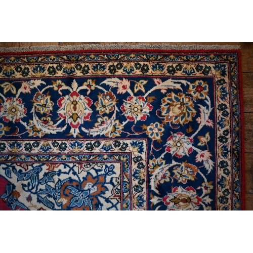 1079 - A central Persian Isfahan carpet, centred by a floral medallion on red ground, 380 cm x 285 cm