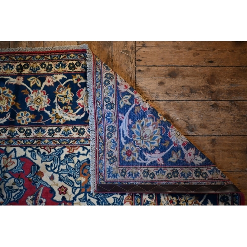 1079 - A central Persian Isfahan carpet, centred by a floral medallion on red ground, 380 cm x 285 cm