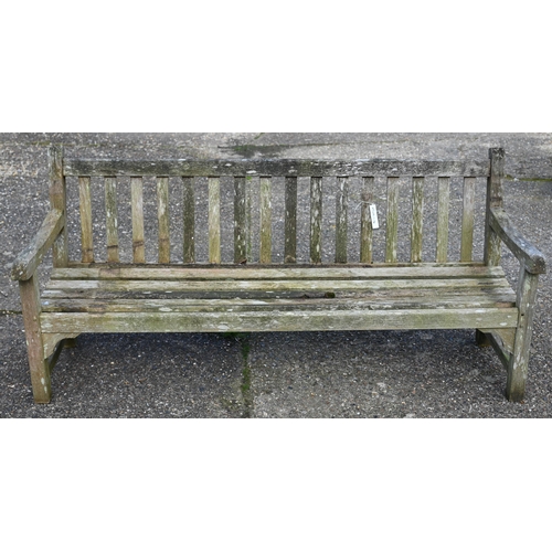 49 - A weathered slatted teak three-seater garden bench, 184 cm wide