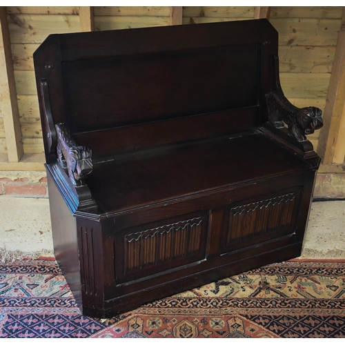 513 - A dark oak metamorphic monks bench with carved top