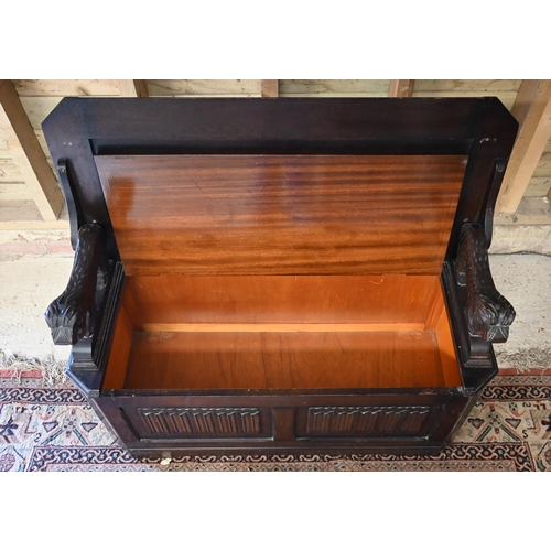 513 - A dark oak metamorphic monks bench with carved top