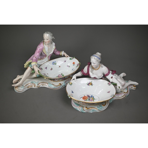 572 - A pair of 19th century Meissen bonbon dishes modelled as floral painted and encrusted baskets held b... 