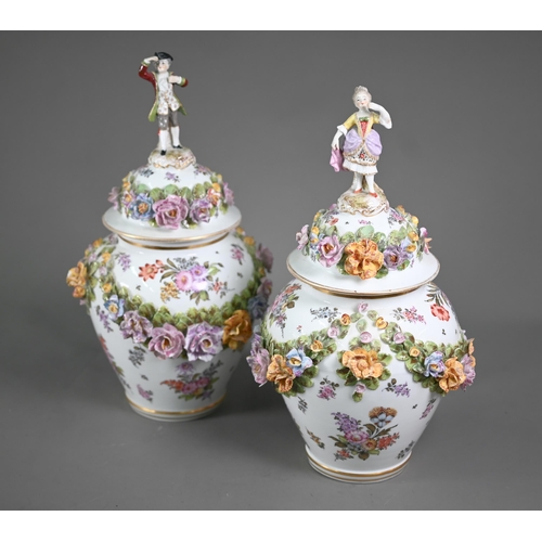 575 - A good pair of German porcelain vases, the domed covers surmounted by an 18th century lady and gentl... 