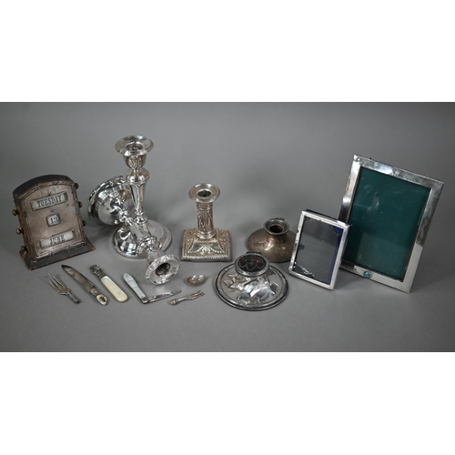 128 - A quantity of loaded silver items including candlesticks, desk calendar, inkwells, photograph frames... 