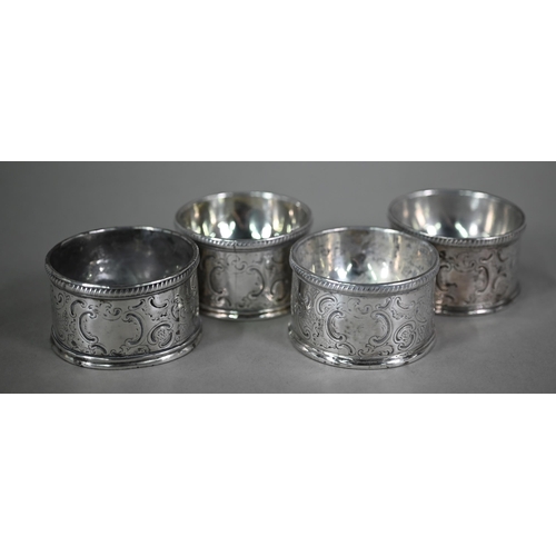 134 - A set of four George III circular silver trencher salts with engraved rococo decoration, maker's mar... 