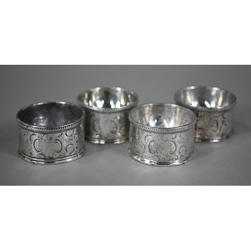 134 - A set of four George III circular silver trencher salts with engraved rococo decoration, maker's mar... 