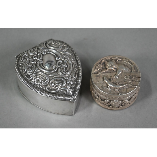 138 - An Edwardian circular silver small box, the cover finely embossed and chased with a cat hunting a li... 