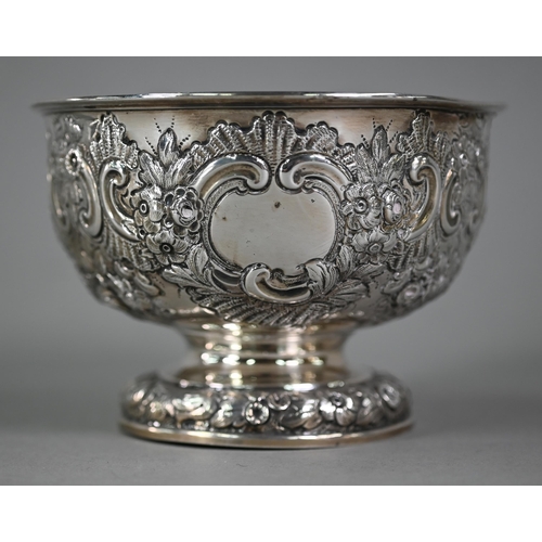 141 - An Edwardian silver rose bowl with embossed and chased floral and scroll decoration, on stemmed foot... 