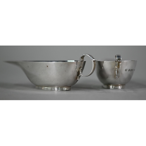 160 - A cased pair of cream jugs of shallow, elongated form with C-scroll handles, S Blanckensee & Son... 