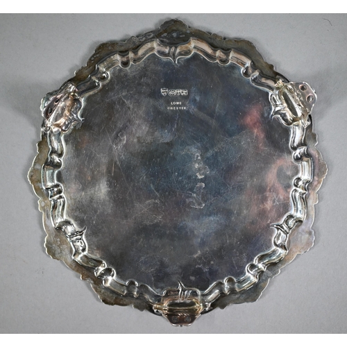 173 - An Edwardian circular silver card salver in the Georgian manner, with shell and scroll moulded borde... 