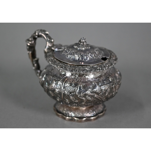 176 - A good George IV silver mustard with hinged cover, scroll handle and stemmed foot, richly embossed a... 